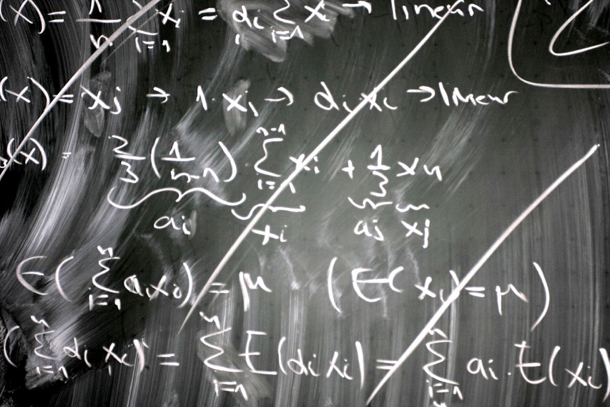 Mathematische Formeln und Gleichungen auf einer beschrifteten Kreidetafel.